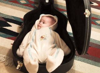 Steady now: a baby in a guitar case.