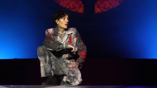 Oli Sykes kneeling on stage looking at the crowd