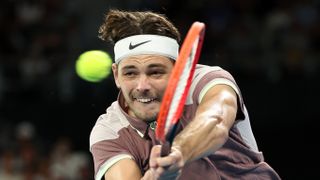  Taylor Fritz of the United States, wearing a white Nike headband, plays a backhand ahead of the Djokovic vs Fritz live stream at the Australian Open 2024 quarter-finals