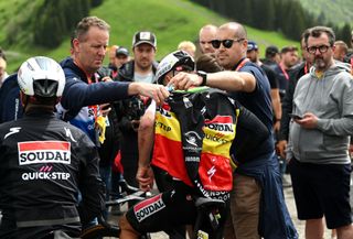 Critérium du Dauphiné stage 7: Remco Evenepoel gets extra clothes from team support staff after the finish
