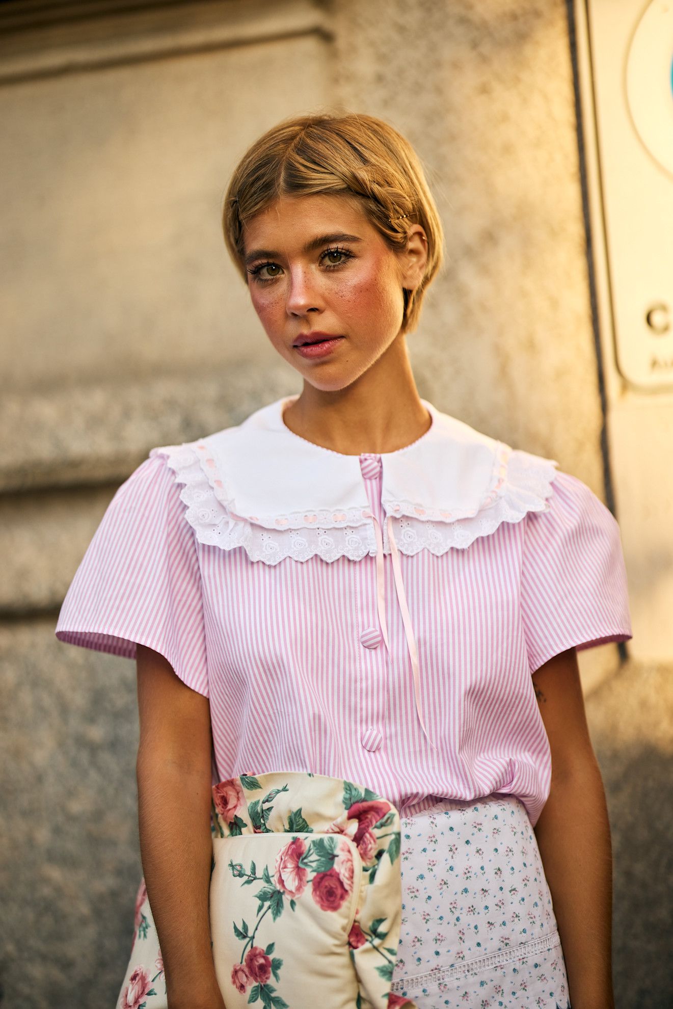 a blonde woman with a pixie cut in a pink shirt