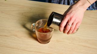 Wacaco Pipamoka portable coffee maker in front of a blue background.