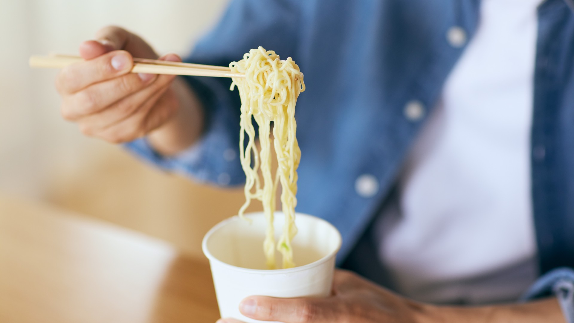Person eating a pot noodle