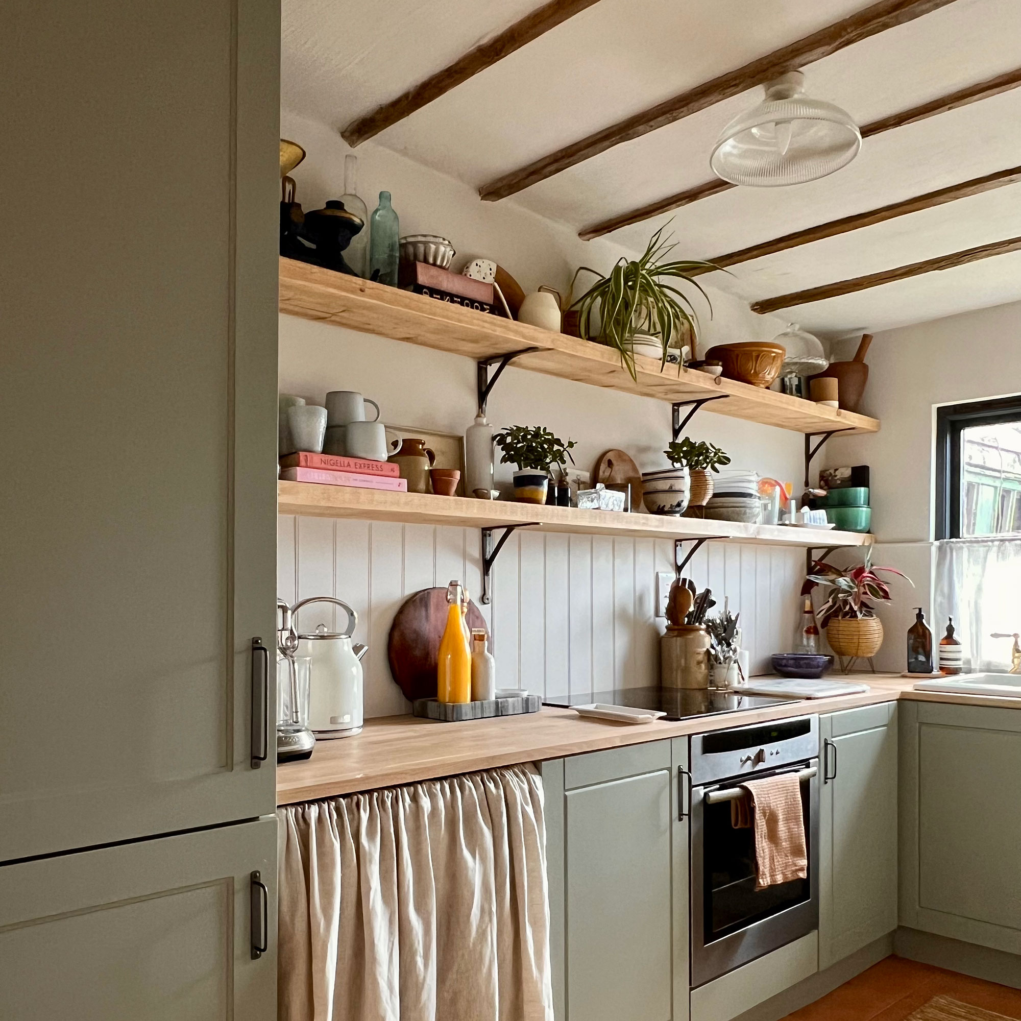 Country kitchen with open shelving and wooden beams