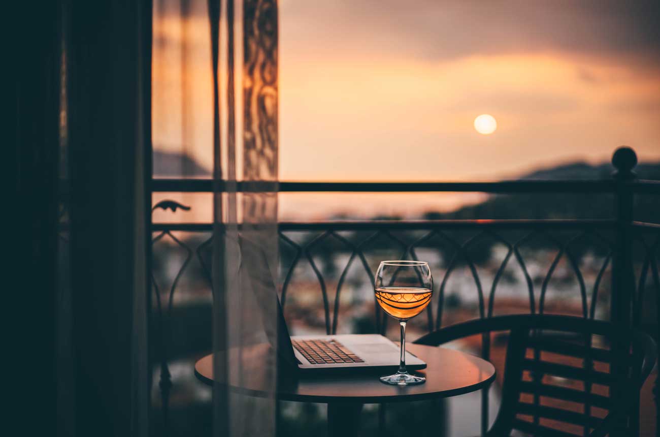 Image of sunset on a balcony with a glass of ros&eacute;
