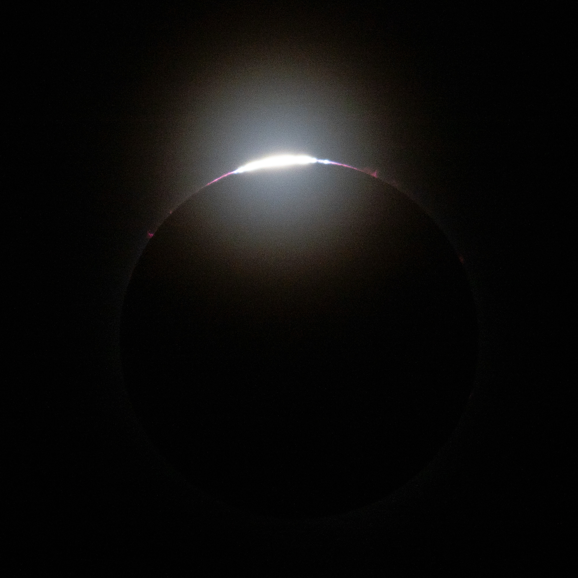 Os últimos raios do sol espreitam através das montanhas da lua nesta imagem do eclipse solar total de 8 de abril.