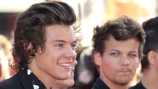 Louis Tomlinson looking at Harry Styles at an event in London in 2013