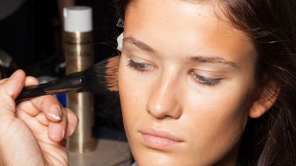 model is seen with a bronzer brush backstage of the Au Jour Le Jour show during Milan Fashion Week Spring/Summer 2018 on September 24, 2017 in Milan, Italy