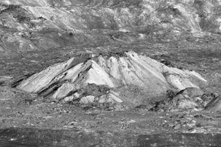 Oblique view of Tycho crater's central peak. A very popular target with amateur astronomers, Tycho is located at 43.37 degrees S, 348.68 degrees E, and is roughly 82 km (51 miles) in diameter. The summit of the central peak is 2 km (6562 ft) above the crater floor, and the crater floor is about 4700 m (15,420 ft) below the rim.