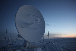 satellite dish above dark sky above Antarctic ice