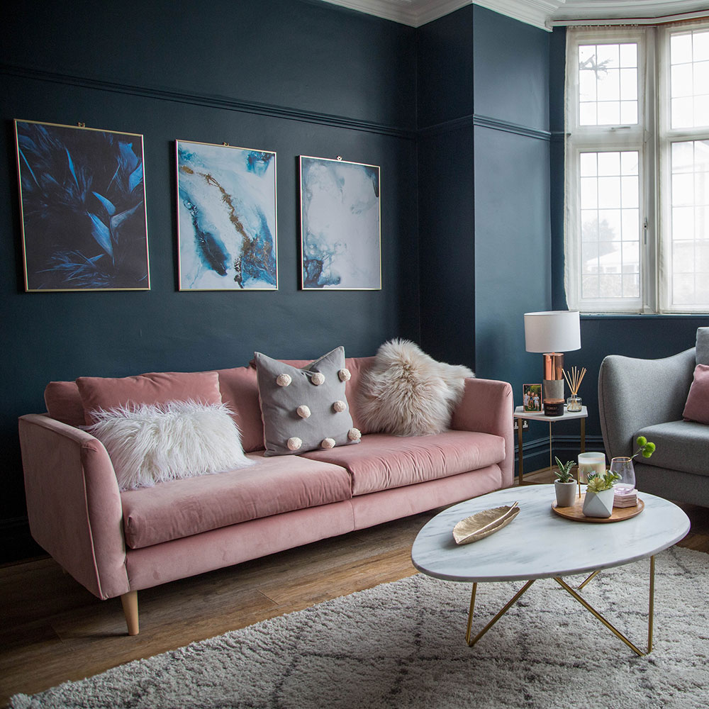 Dark inky blue living room with a pink sofa