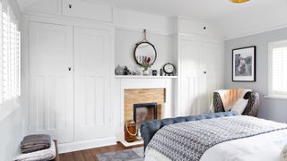 grey bedroom with wall of bespoke built-in closets to show how to organize a small bedroom effectively