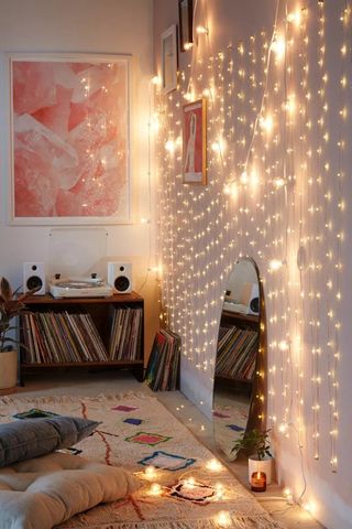 A bedroom with warm LED lights with round mirror, ethnic style carpet and record player