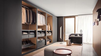 A large walk in wardrobe with built in closets with sliding black doors