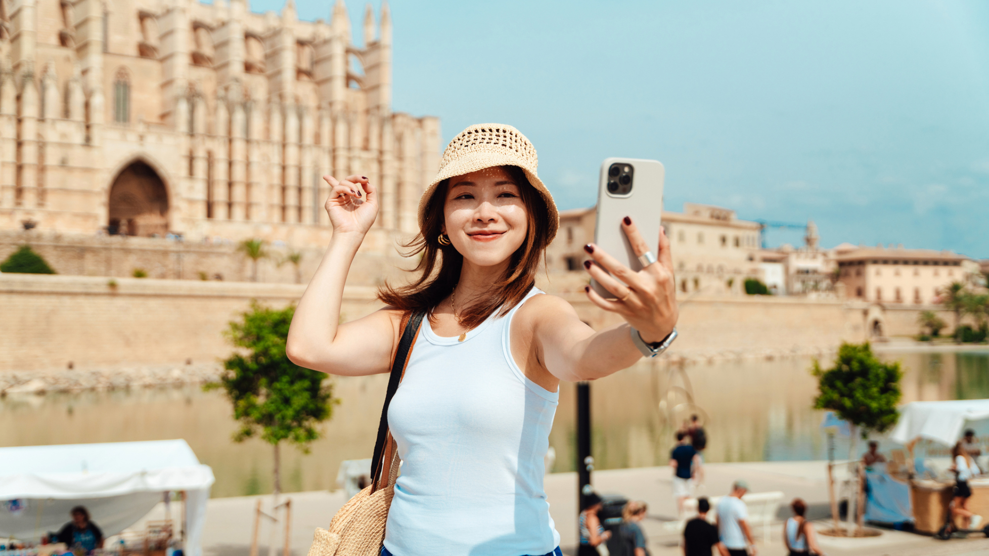 A tourist with an iPhone taking a selfie.