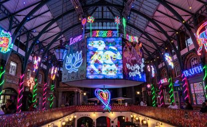 Chila Burman's neon installation,  Do you see words in rainbows, at Covent Garden market. Photography: Covent Garden/Jeff Moore