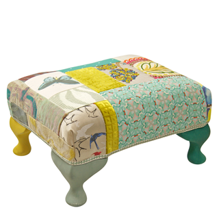 Bright multicoloured patterned footstool with wooden legs