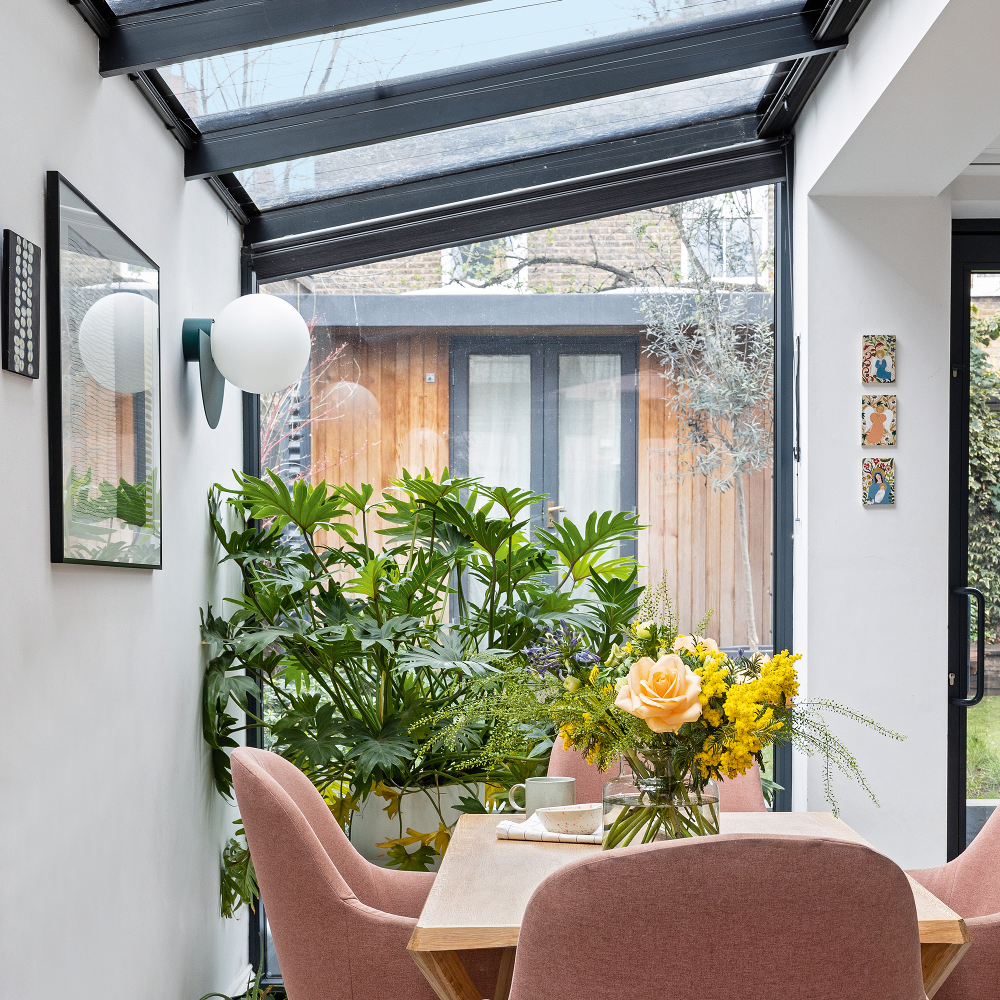 a side return extension with a wooden dining table and pink upholstered dining chairs