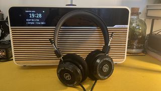 Grado SR80x headphones placed on Ruark R2 Mk4 radio on yellow table