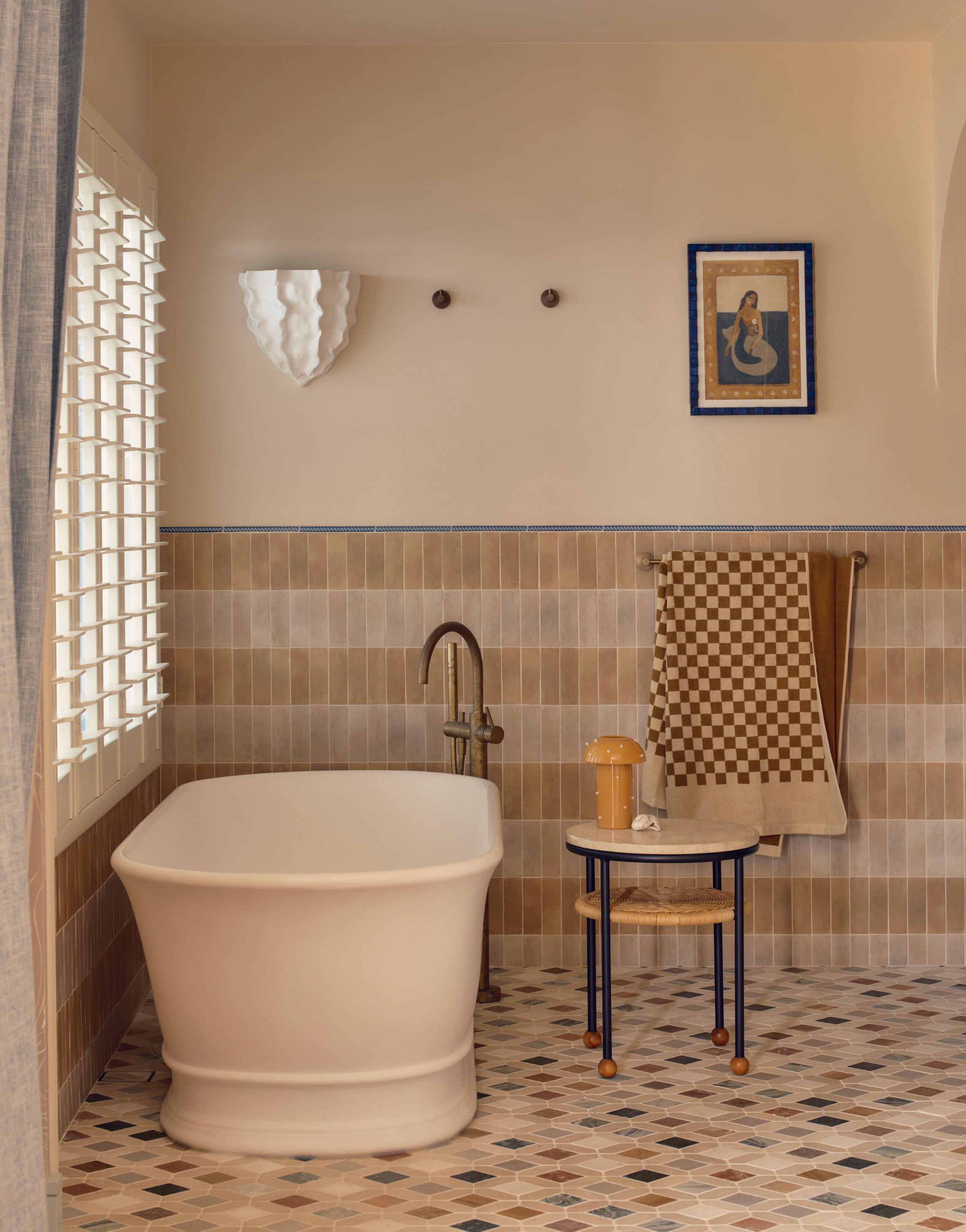 A bathroom in muted tones, with graphic colorful floor tiles