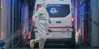 A hospital worker being sprayed with disinfectant in Coronation