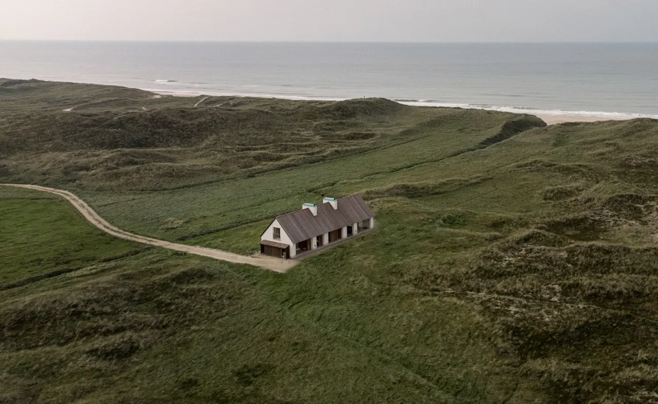 A guesthouse in the middle of a green landscape by the coast