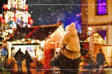 A child on their parents shoulders at a Christmas market in the UK