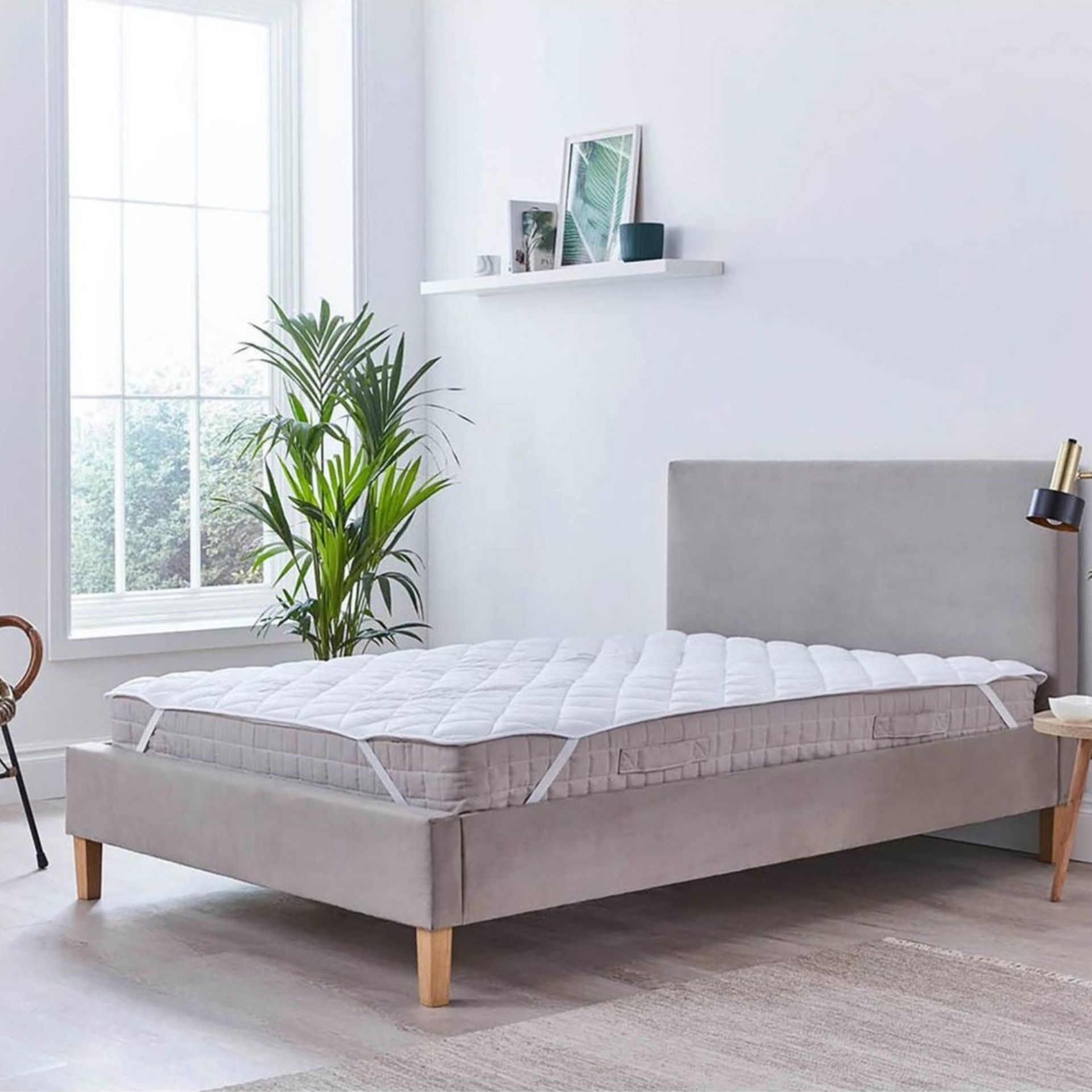 White mattress topper on grey bed