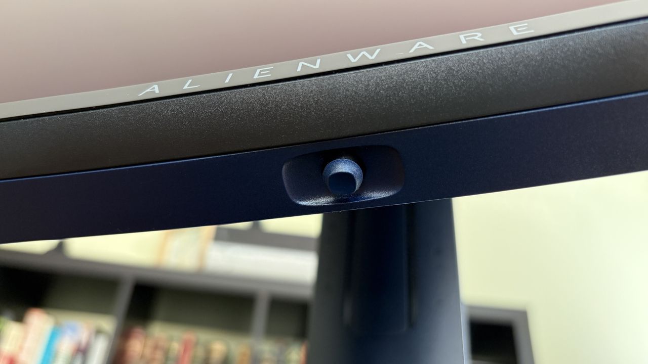 Close-up of an Alienware monitor's top edge featuring the brand name and a button for adjustments.