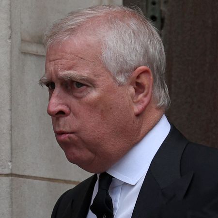 The former Prince Andrew wears a black suit with a white tie and has white gray hair and appears to be pursing his lips