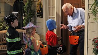 Buzz Aldrin cameo in the tv show the Big Bang Theory, he is pictured here answering the door to three children dressed in Halloween costumes and holding a bucket with a pumpkin face on.