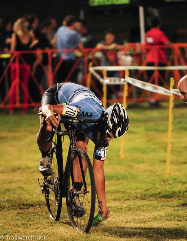 A rider at the back of the pack takes a moment to pick up a beer