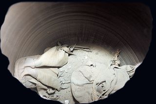 Archaeologists discovered seven shoes, that appear to be made out of bovine, within a jar in an Egyptian temple. The shoes date back more than 2,000 years and this picture shows the inside of the jar before the shoes were removed.