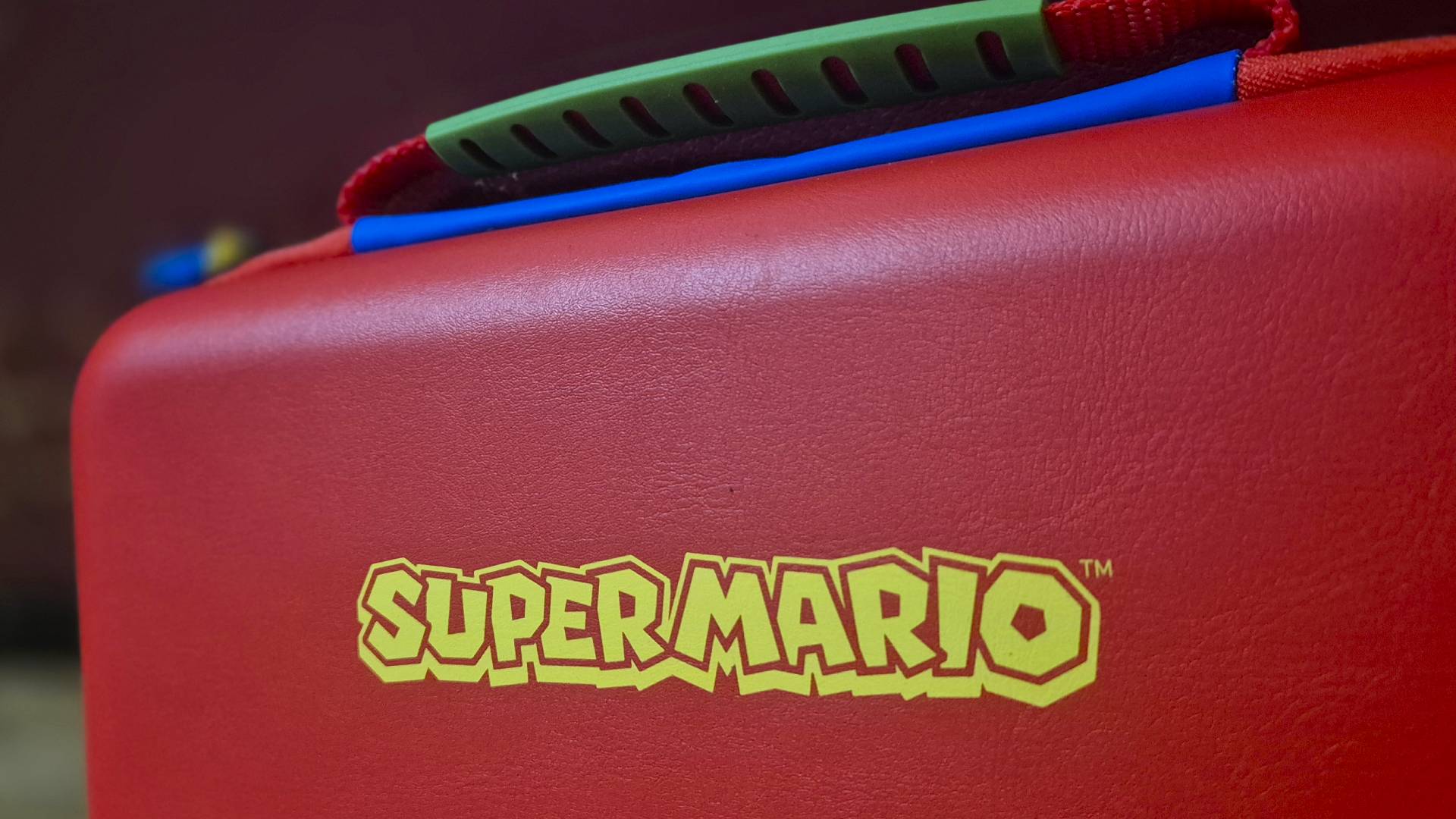 Photo of the back of a Switch 2 case that shows a yellow Super Mario logo on top of a red background.
