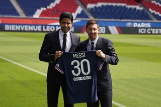 Lionel Messi, right, and PSG president Nasser Al-Al-Khelaifi hold Messi’s number 30 shirt after his unveiling (Francois Mori/AP)