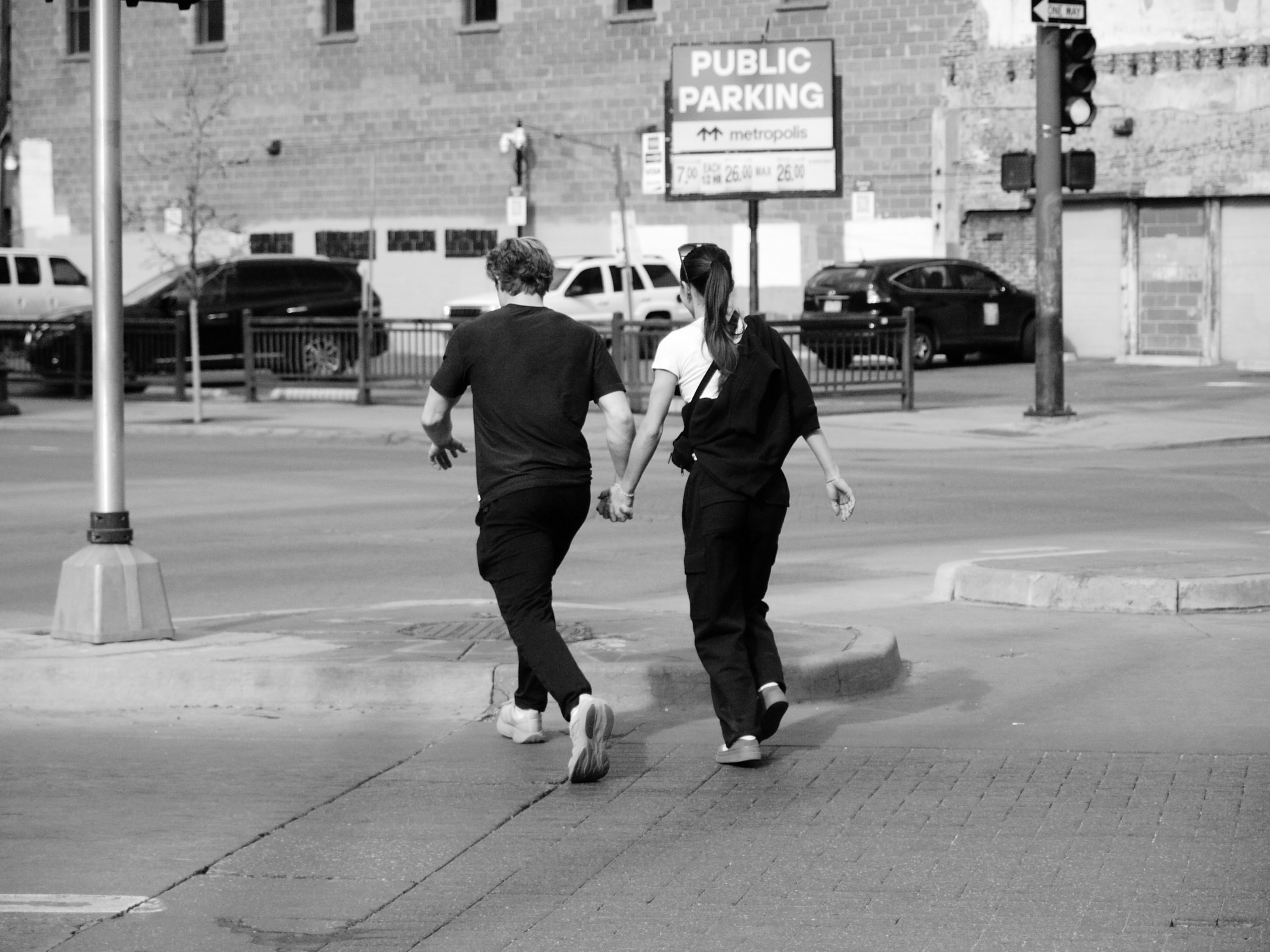 A street photo of two people walking while holding hands, shot on the Lumix L1