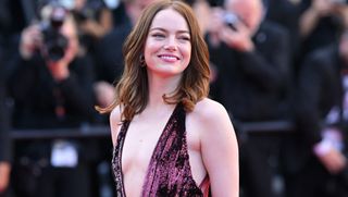 Emma Stone wears a purple louis vuitton gown with sequins and a deep plunge neckline