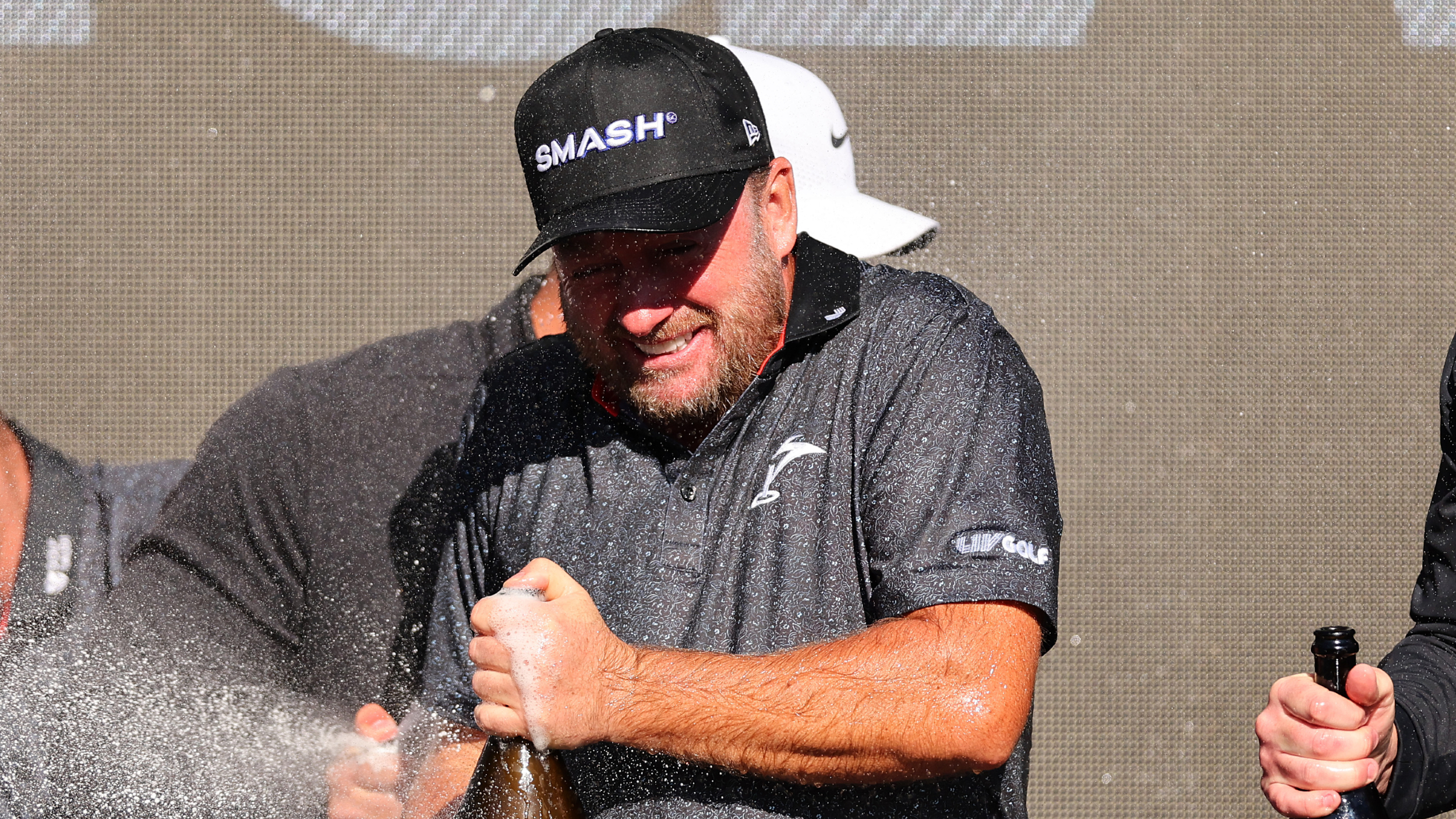 Graeme McDowell pops the cork on a champagne bottle