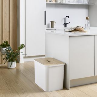 room with wooden flooring and white coloured recycle bin