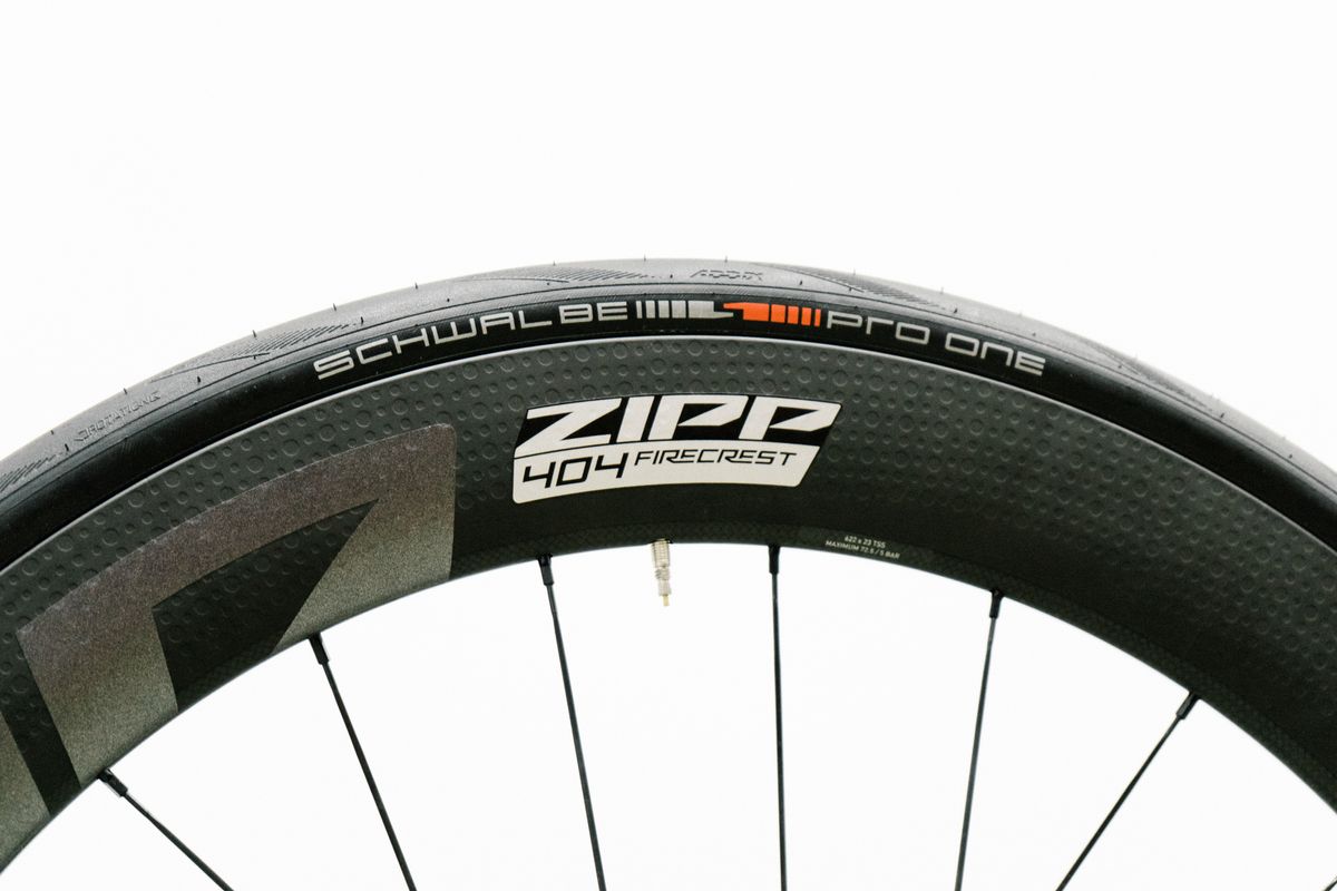 An aero road wheel stands against a white wall