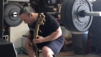 A man squatting 225 pounds while playing a Metallica song