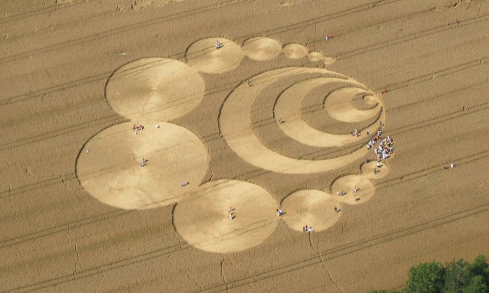 People inspect crop circles within a golden wheat field in Switzerland. The photo was taken on July 29, 2007.