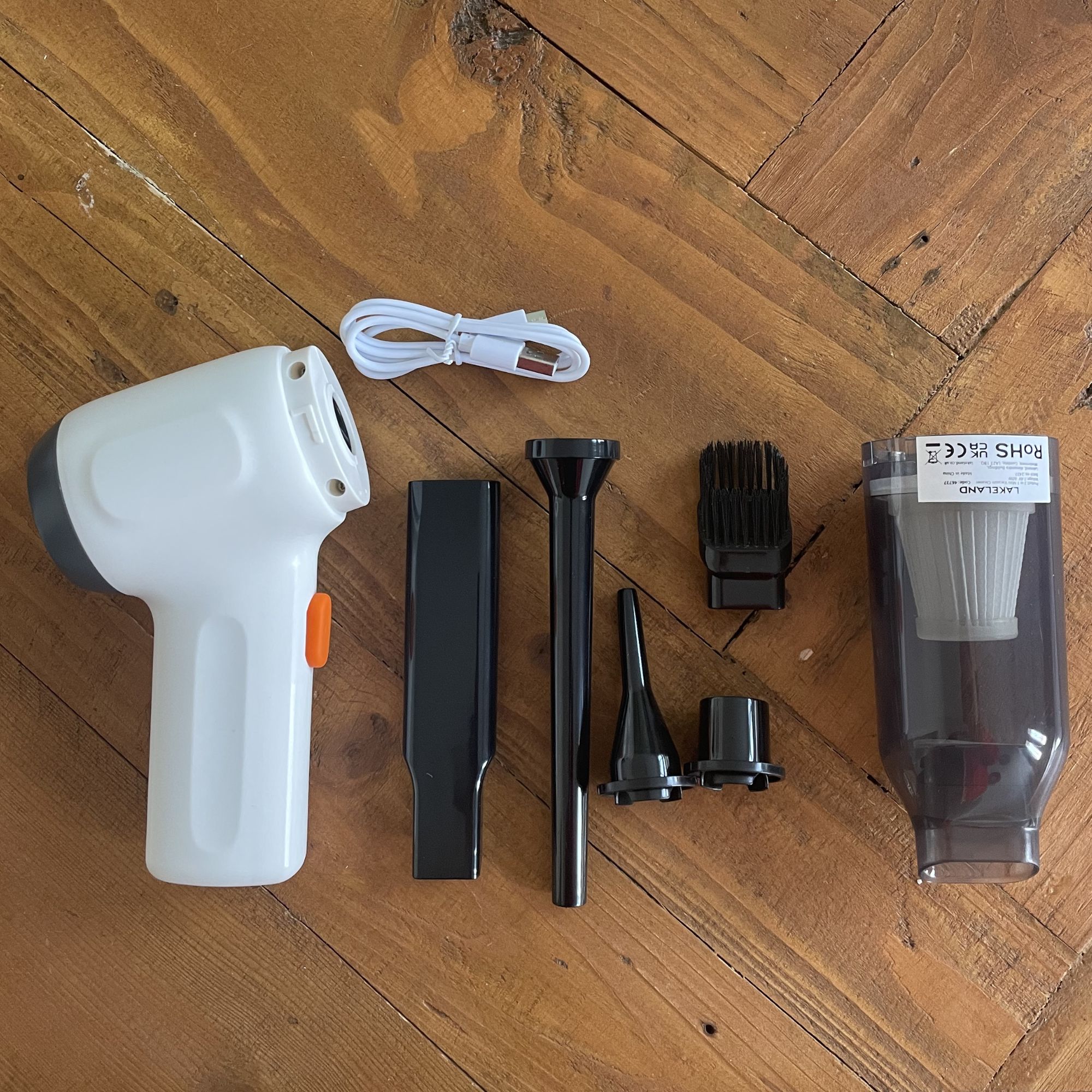 Lakeland mini vacuum cleaner and its tools deconstructed and laying on a wooden table