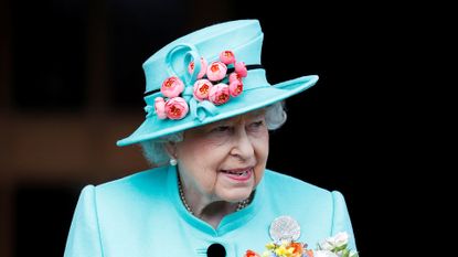 Queen Elizabeth II wearing a blue hat with a floral desin