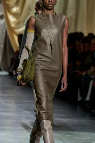 Model at Fendi Fall/Winter 2024 wearing maximal accessories like leather bangles and a knit sweater sleeve