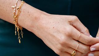 close-up shot of Meghan Markle's hand and wrist wearing dainty gold jewellery