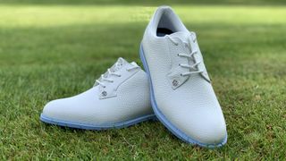 The classy G/Fore women's gallivanter golf shoes resting on the course showing off their stunning all-white colorway