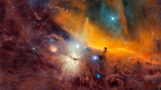A nebula scene is shown with swirling clouds of brown, red and orange. Blue and white stars can be seen dotted throughout.