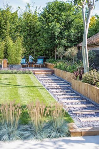 long garden ideas: narrow plot with stepping stone pathway and seating area at the bottom