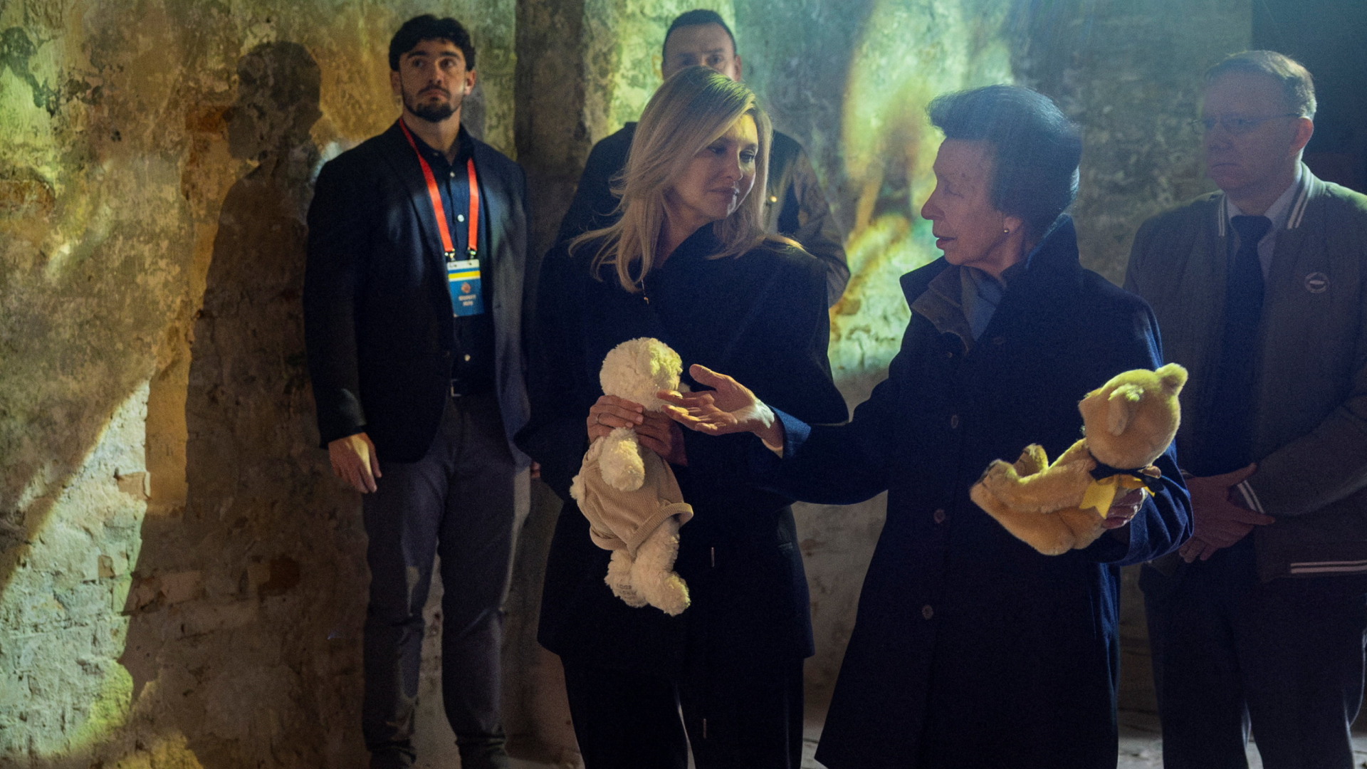Princess Anne and First Lady Olena Zelenska wearing coats and holding teddy bears at a memorial for children in Kyiv, Ukraine